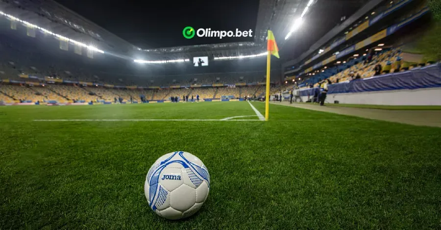 cancha de fútbol vista a ras del suelo en perspectiva con una pelota en primer plano